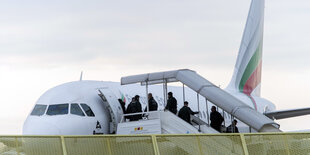 abgelehnte asylbewerber steigen in ein flugzeug bei einer sammelabschiebung