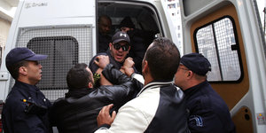 22.02.2019, Algerien, Algiers: Algerische Polizisten verhaften einen Demonstranten bei Protesten gegen die Kandidatur des algerischen Präsidenten Bouteflika für eine fünfte Amtszeit.