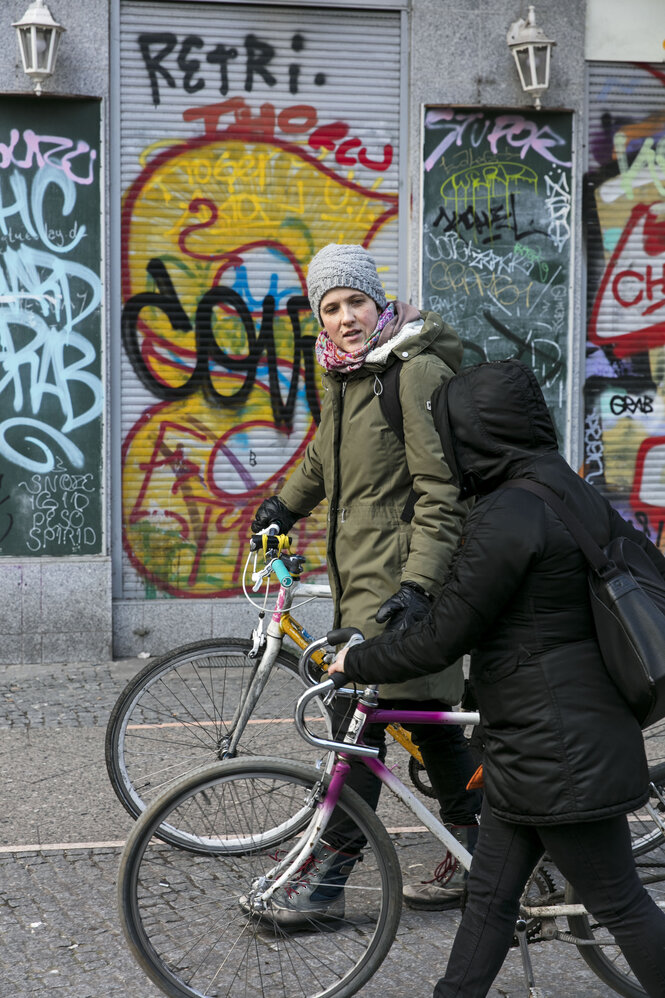 Zwei Frauen schieben Fahrräder auf der Straße