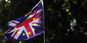 Eine britische und eine EU-Flagge wehen übereinandergelegt im Wind