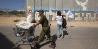 Ein israelischer Soldat schiebt einen Einkaufswagen mit Ausrüstung entlang der israelischen Grenze im Gaza-Streifen.