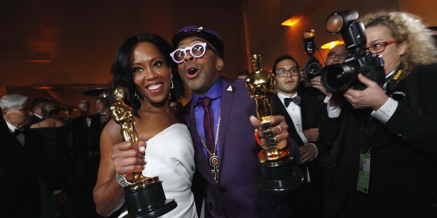 Zwei Personen halten Oscars in den Händen und freuen sich