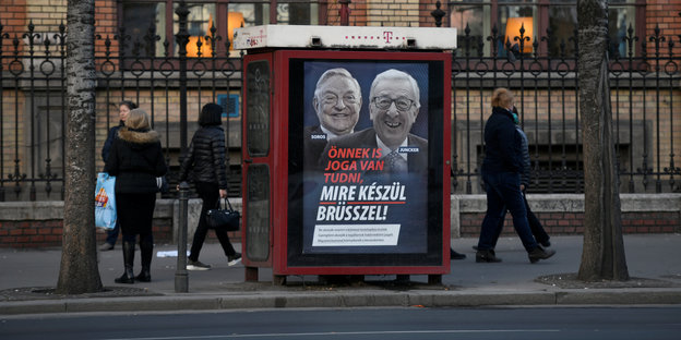An einer Bushaltestelle hängt ein Poster der ungarischen Regierung gegen Jean-Claude Juncker