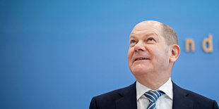 Olaf Scholz vor einem blauen HIntergrund