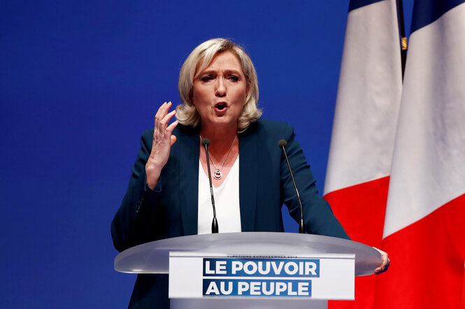 Die französische Rechtspopulistin Marine Le Pen steht vor einer Frankreich-Flagge an einem Pult und redet