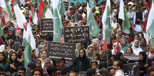 Viele Menschen tragen pakistanische Flaggen und Plakate gegen Indien