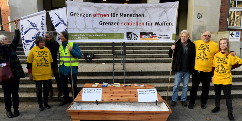 Sieben DemonstrantInnen mit Banner. Aufschrift: "Grenzen öffnen für Menschen. Grenzen schließen für Waffen."