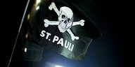 Eine schwarze Flagge mit weißem Totenkopf und "St Pauli"-Aufschrift