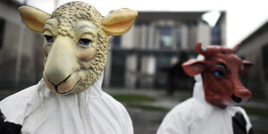 Tierrechtler, die sich als Schaf und Rind verkleidet haben, protestieren vor dem Kanzleramt in Berlin