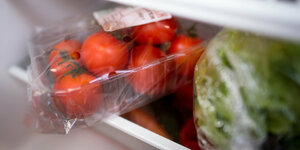 In Plastik gehüllte Tomaten und Salat