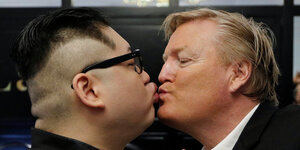 Trumps und Kim Jong Uns Double küssen sich