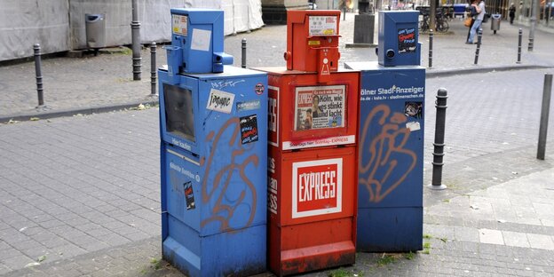 Zeitungskästen der "Kölnischen Rundschau", "Express" und "Kölner Stadt-Anzeiger" stehen nebeneinander