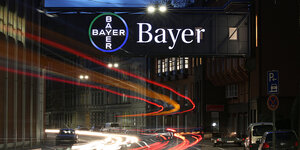 Bayer-Logo im Dunkeln über einer Straße
