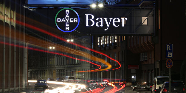 Bayer-Logo im Dunkeln über einer Straße