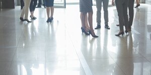 Beine von Männern und Frauen in Businesskleidung