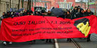 Teilnehmer einer Demonstration in Gedenken an Oury Jalloh ziehen durch Dessau-Roßlau.