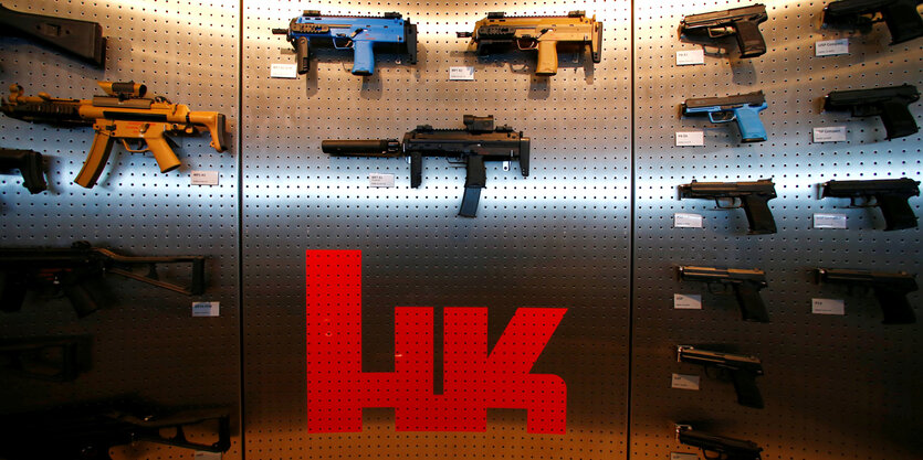 Verschiedene Waffen von Heckler & Koch werden an einer Wand präsentiert.