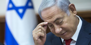 Benjamin Netanjahu fasst sich an die Stirn.