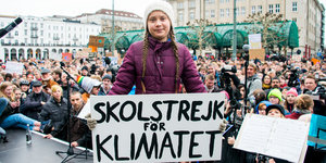 Greta Thunberg mit einem Schild