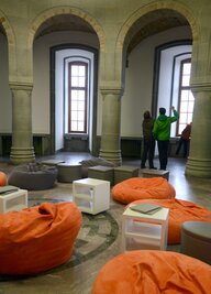 Raum mit Säulen und orangenen Sitzkissen