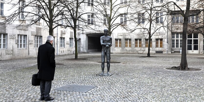 Geplasterter Hof mit Skulptur und Häusern