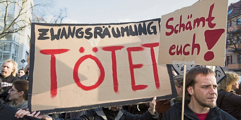 Demonstranten tragen ein Plakat mit der Aufschrift "Zwangsräumung tötet".