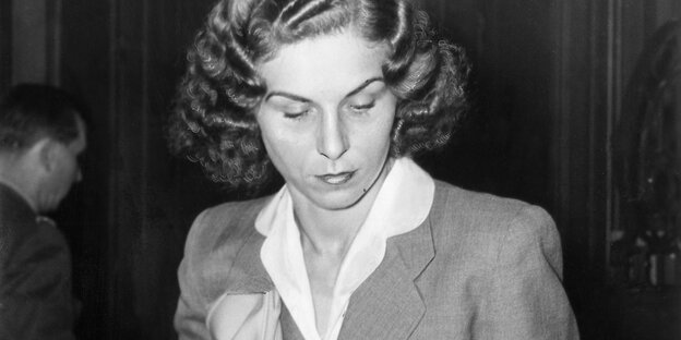 Ein schwarz-weiß-Bild einer jungen Frau in Bluse und Blazer, die ihre Haare im Stil der 1950er Jahre gewellt hat
