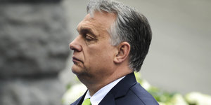 Viktor Orbán steht links zum Bild und guckt streng