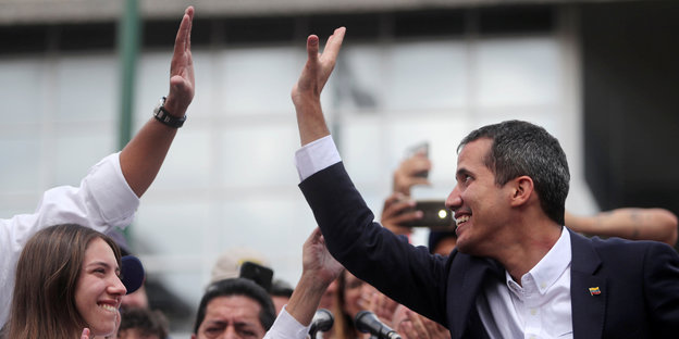 Ein Mann klatscht in die Hand einer anderen Person. Es ist Juan Guaidó