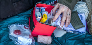 Eine Hand auf einer Prepper-Zubehör-Box, mit der ein Mann individuellen Katastrophenschutz betreibt.
