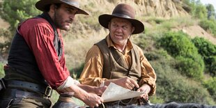 Joaquin Phoenix und John C. Reilly sitzen als Cowboys auf den Rücken ihrer Pferde