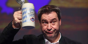 Markus Söder hält einen Bierkrug in die Luft