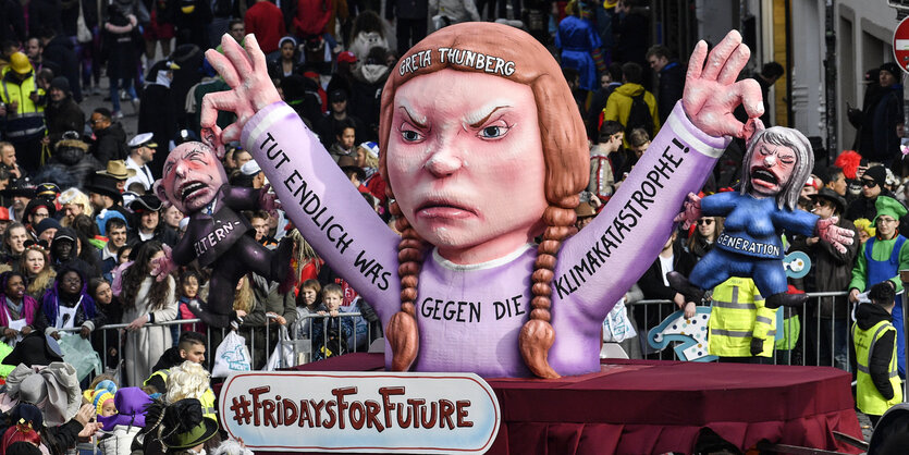 Karnevalswagen zeigt Aktivistin Greta Thunberg, die die Elterngeneration am Kragen packt