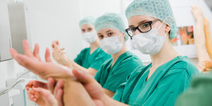 Ärztinnen tragen Mundschutz und desinfizieren ihre Hände