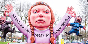 Ein Karnevalswagen stellt die junge schwedische Klimaaktivistin Greta Thunberg dar, die der Elterngeneration die Ohre langzieht