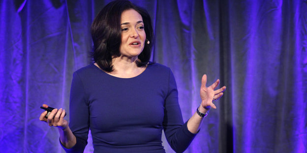 Sheryl Sandberg vor einem violetten Vorhang bei einer Präsentation