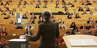 Eine Professorin steht vor einem vollen Hörsaal