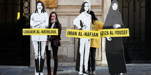 Frauen halten lebensgroße Pappfiguren von drei saudi-arabischen Aktivistinnen hoch