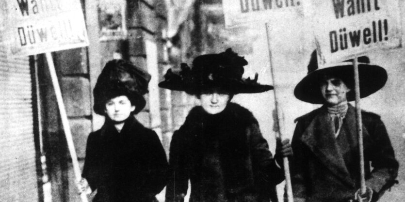 Historisches Foto: Frauen werben auf Plakaten für einen Kandidaten