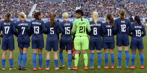 Das US-Frauenfußballteam steht mit dem Rücken zur Kamera