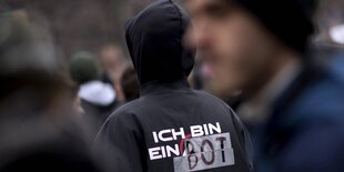 Jemand mit einer Jacke, auf der steht: "Ich bin ein Bot"