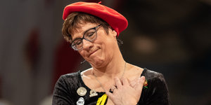 Annegret Kramp-Karrenbauer mit roter Baskenmütze und geschlossenen Augen