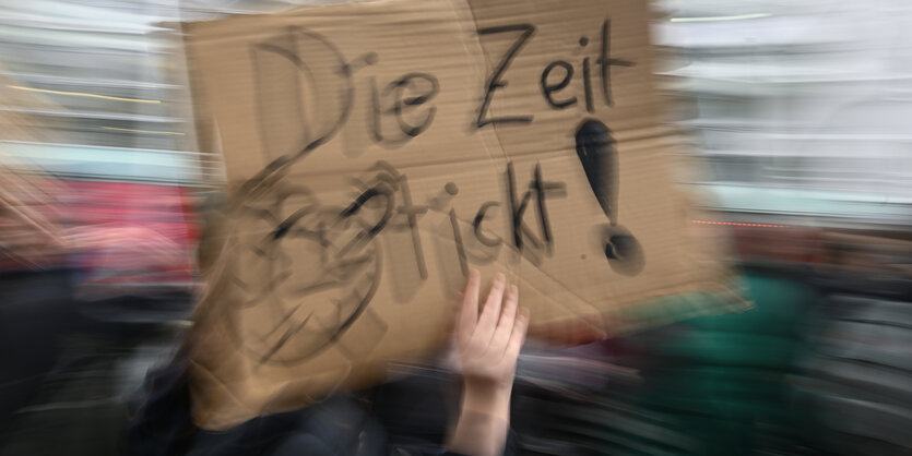 Protestplakat sagt: Die Zeit tickt