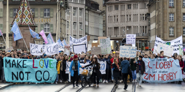 In Basel demonstrieren Menschen mit Schildern und Bannern während einer „Klimastreik“-Demonstration