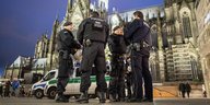 Eine Gruppe von Polizisten am Abend vor dem Kölner Dom