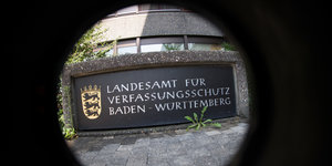 Das Eingangsschild des baden-württembergischen Landesamt für Verfassungsschutz, aufgenommen durch eine Sonnenblende mit FishEye-Objektiv.