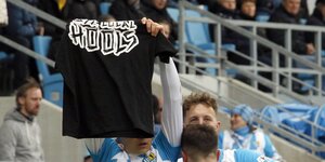 Ein Spieler des FC Chemnitz hält ein Hooligan-Tshirt in die Höhe