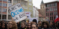 Eine Teilnehmerin hält während der Klimaschutz-Demonstration «Fridays for Future» ein Schild hoch, auf dem «Like the oceans we rise» steht