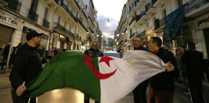 Algerier halten ihre Nationalflagge, während sie in den Straßen von Algier feiern