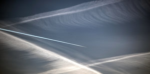 Ein Flugzeug zieht Kondesstreifen am Himmel